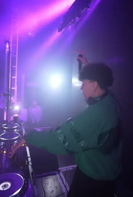 Nicole Keri performing a DJ set under purple stage lighting