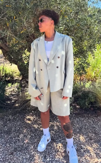 Full-length outdoor portrait of Nicole Keri in light tailoring